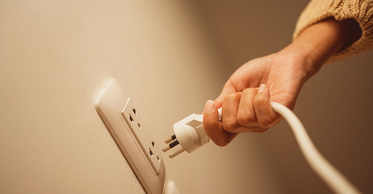 Home electrical safety inspection: electrician checking circuit breaker panel, testing GFCI outlet, and inspecting wiring with voltage tester